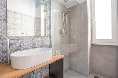 a bathroom with a white tub and a shower at Elegantis Des Artistes Apartment in Rome