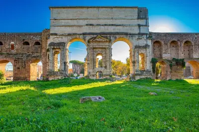 an old building with arches in a field at Elegantis Des Artistes Apartment in Rome