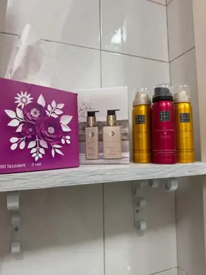 a shelf with four bottles of soap and a box at Giosephine House in Rome