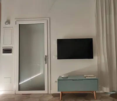 a sliding glass door with a television on a wall at Rare Seed Trastevere in Rome