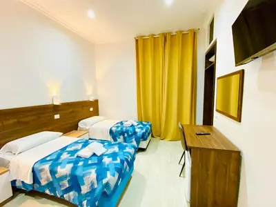 a hotel room with two beds and a desk at Milazzo Suites in Rome