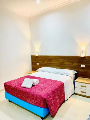 a bedroom with a large bed with a red blanket at Milazzo Suites in Rome