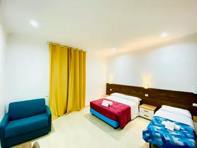 a hotel room with a bed and a blue chair at Milazzo Suites in Rome