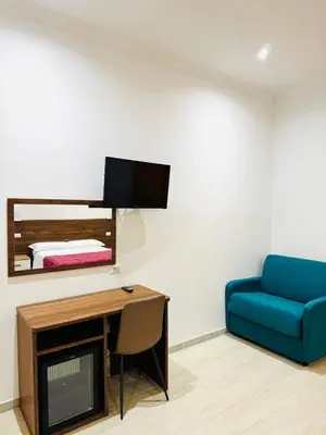 a living room with a blue couch and a tv at Milazzo Suites in Rome