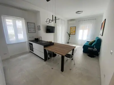 a kitchen and living room with a wooden table at Casa vacanze Belsito in Rome