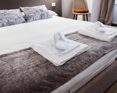a bed with white towels and slippers on it at Casa Fortuna 278 in Rome