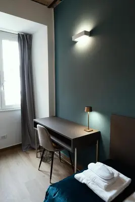 a room with a desk and a bed and a window at Casa Fortuna 278 in Rome