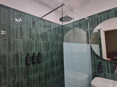 a green tiled bathroom with a shower and a toilet at Casa Fortuna 278 in Rome