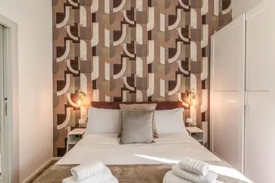 a bedroom with a bed and a wall with patterns at St Peter Miracle Suite in Rome