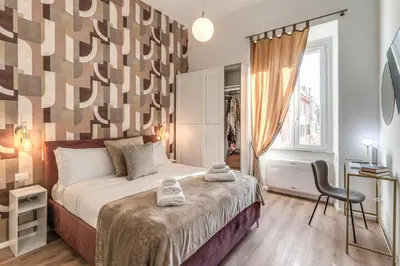 a bedroom with a bed and a chair and a window at St Peter Miracle Suite in Rome