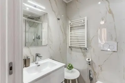 a white bathroom with a sink and a mirror at St Peter Miracle Suite in Rome