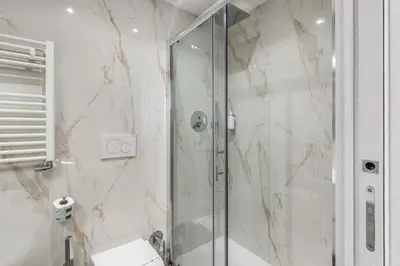 a bathroom with a shower with a glass door at St Peter Miracle Suite in Rome