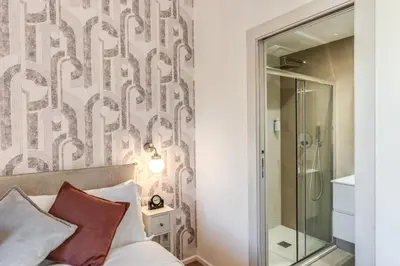 a bedroom with a bed and a glass shower at St Peter Miracle Suite in Rome