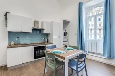 a kitchen and dining room with a table and chairs at Domus Alessandro City Apartment in Rome