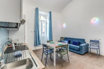 a kitchen and living room with a table and a couch at Domus Alessandro City Apartment in Rome