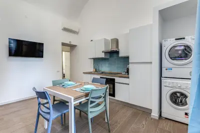 a kitchen and dining room with a table and chairs at Domus Alessandro City Apartment in Rome