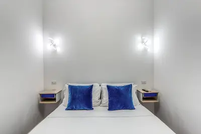 a bed with two blue pillows in a room at Domus Alessandro City Apartment in Rome