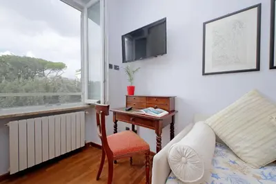 a living room with a bed and a desk with a tv at YCH-Luminoso appartamento nel cuore di Testaccio in Rome