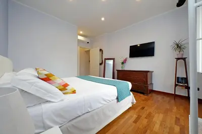 a bedroom with a white bed and a television at YCH-Luminoso appartamento nel cuore di Testaccio in Rome