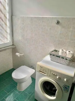 a bathroom with a washing machine and a toilet at Lovely apartment near Rome Vatican in Rome