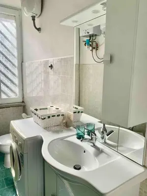 a bathroom with a sink and a toilet and a mirror at Lovely apartment near Rome Vatican in Rome