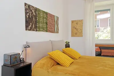 a bedroom with a bed with yellow pillows on it at YCH-Riboty House al Vaticano in Rome
