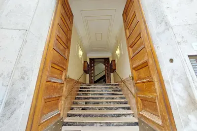a staircase in a building with wooden doors at YCH-Riboty House al Vaticano in Rome