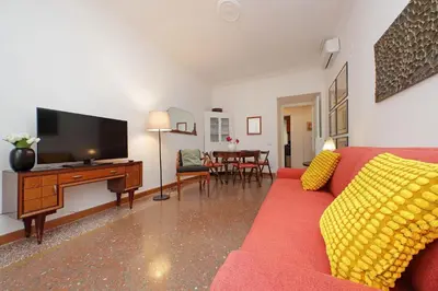a living room with a red couch and a flat screen tv at YCH-Riboty House al Vaticano in Rome
