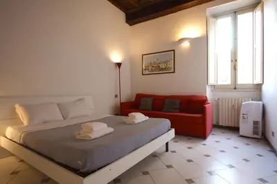 a bedroom with a bed and a red couch at Lovely studio in Campo de Fiori in Rome