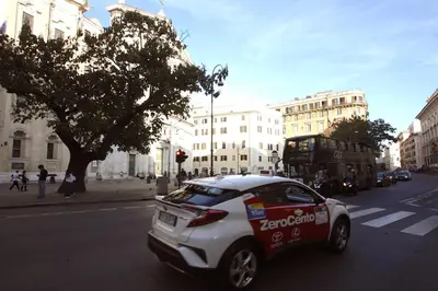 a white and red car driving down a city street at Top floor studio in Campo de Fiori in Rome