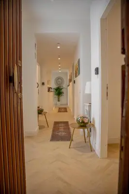 a hallway with a door and a table and a rug at San Pietro Luxury Relais in Rome