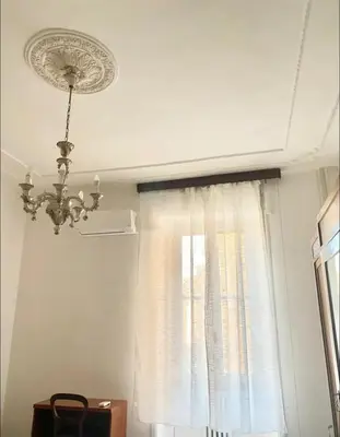 a chandelier hanging from a ceiling in a room with a window at Martino rooms Termini in Rome