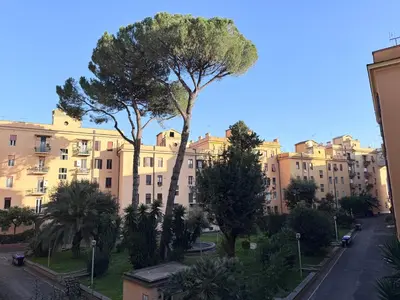 two trees in the middle of a street with buildings at Martino rooms Termini in Rome