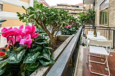 a balcony with pink flowers and a table and chairs at Inside Rome in Rome