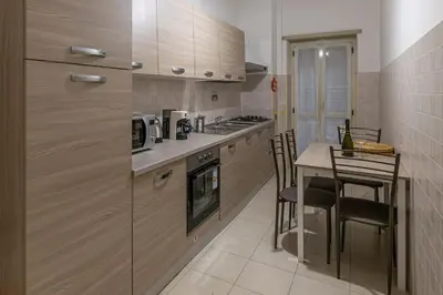 a kitchen with wooden cabinets and a table with chairs at Inside Rome in Rome