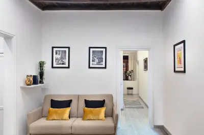 a living room with a couch with yellow pillows at Appartamento Roma Prefetti Suite in Rome