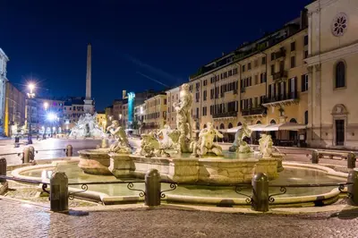 a fountain in the middle of a city at night at Appartamento Roma Prefetti Suite in Rome