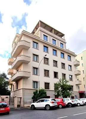 a large white building with cars parked in front of it at san giovanni - re di roma apartment in Rome