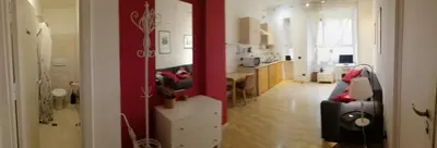 a kitchen and living room with a red wall at san giovanni - re di roma apartment in Rome
