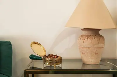 a lamp on a glass table with a mirror and a bowl of flowers at Flaminio center house in Rome