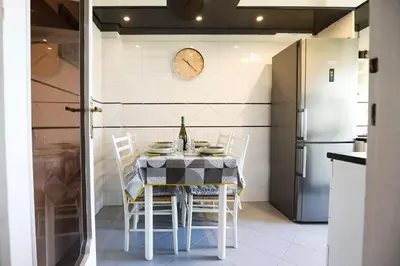 a kitchen with a table with chairs and a clock on the wall at Flaminio center house in Rome