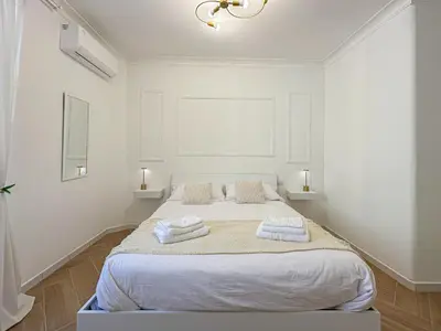 a white bedroom with a bed with towels on it at Lilla Boutique Apartment in Rome