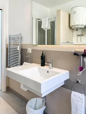 a bathroom with a white sink and a mirror at Lilla Boutique Apartment in Rome