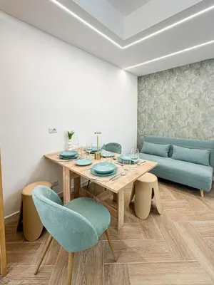 a dining room with a table and blue chairs at Lilla Boutique Apartment in Rome