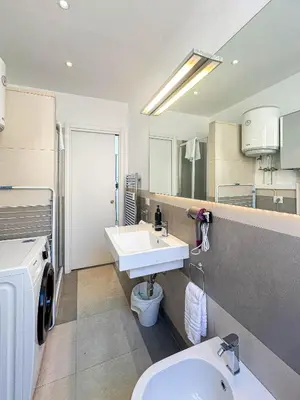 a bathroom with a sink and a washing machine at Lilla Boutique Apartment in Rome