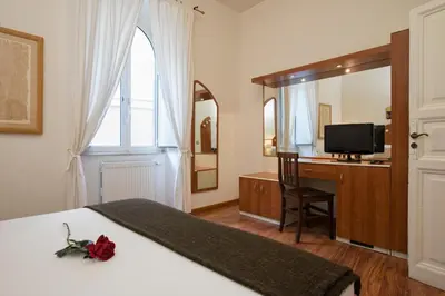 a bedroom with a bed and a desk and a television at Navona Tower Apartments in Rome