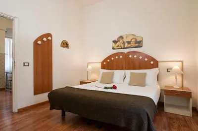 a bedroom with a large bed with a wooden headboard at Navona Tower Apartments in Rome
