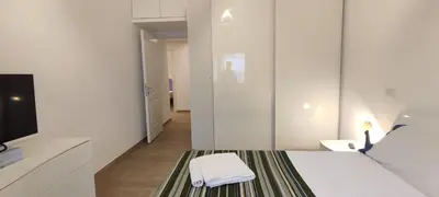 a white room with a bed and a tv at Casetta Cerquetti, a Monteverde in Rome