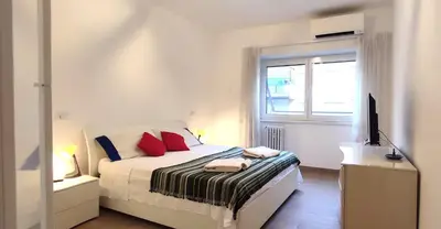 a bedroom with a bed with red pillows and a television at Casetta Cerquetti, a Monteverde in Rome