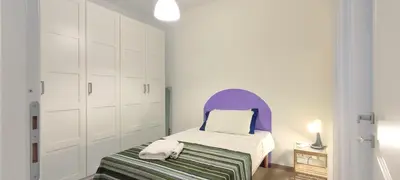 a small bedroom with a bed and a purple headboard at Casetta Cerquetti, a Monteverde in Rome